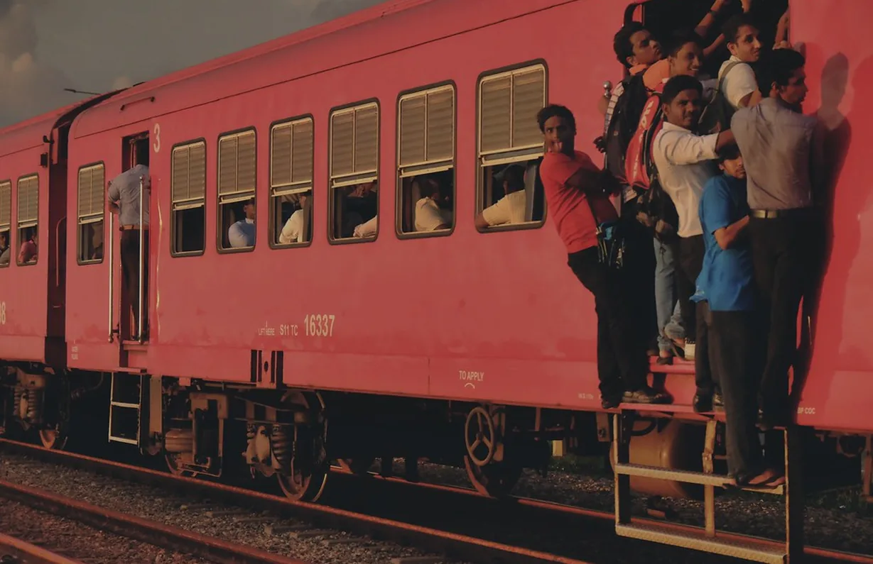 Passengers stepping down from a red country train, photographed as it happened